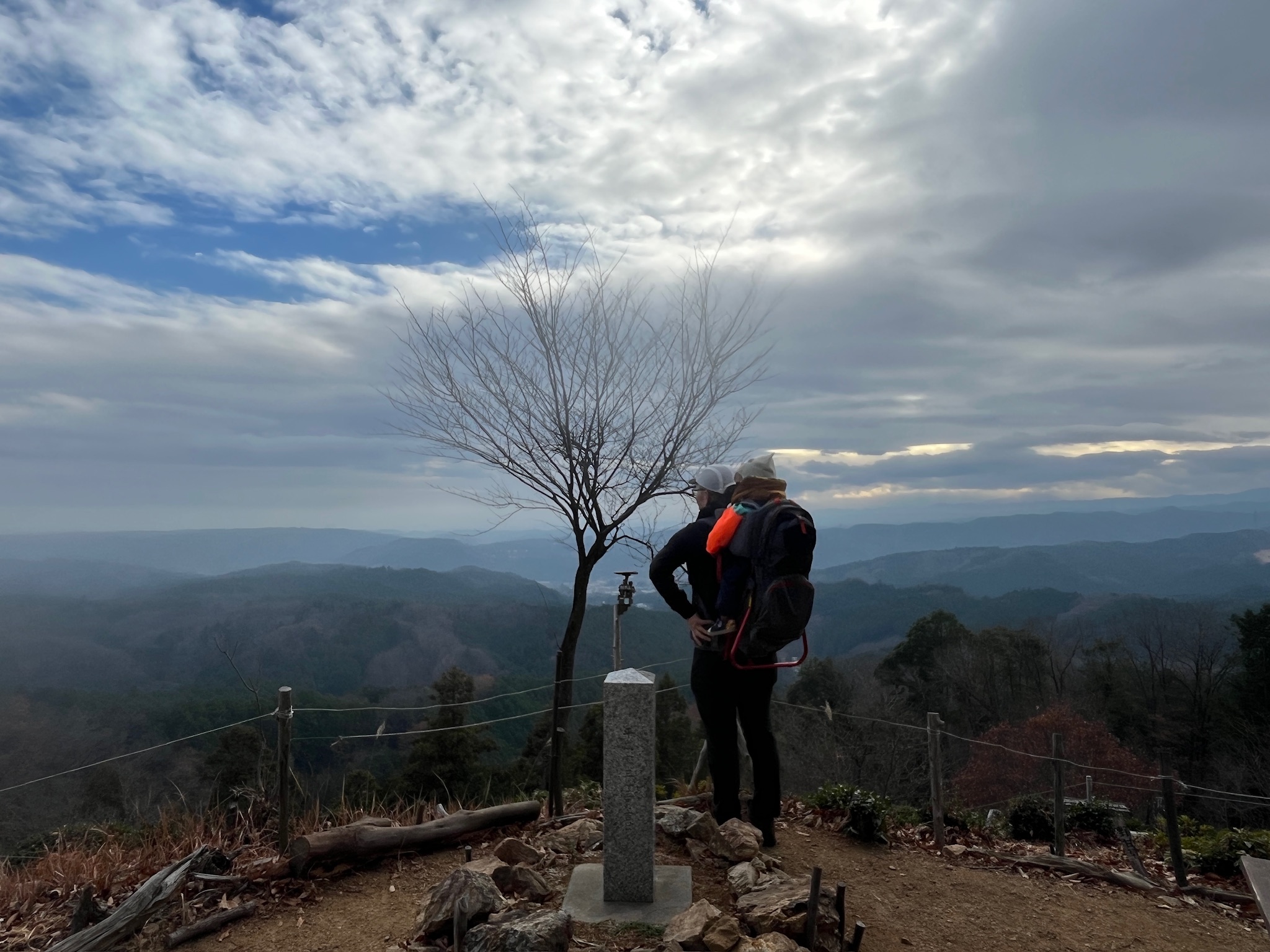 子どもを背負って柏木山山頂に立つ親子の後ろ姿