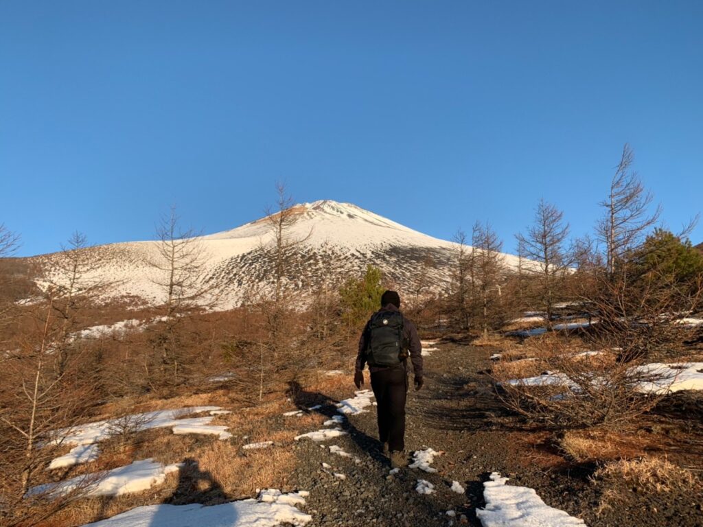 冬の低山を防寒対策した服装で歩く登山の様子
