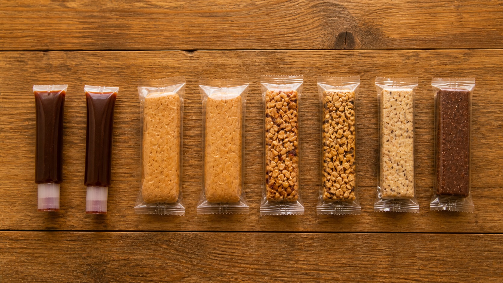 木製テーブルに並ぶ糖分系の行動食フラットレイ