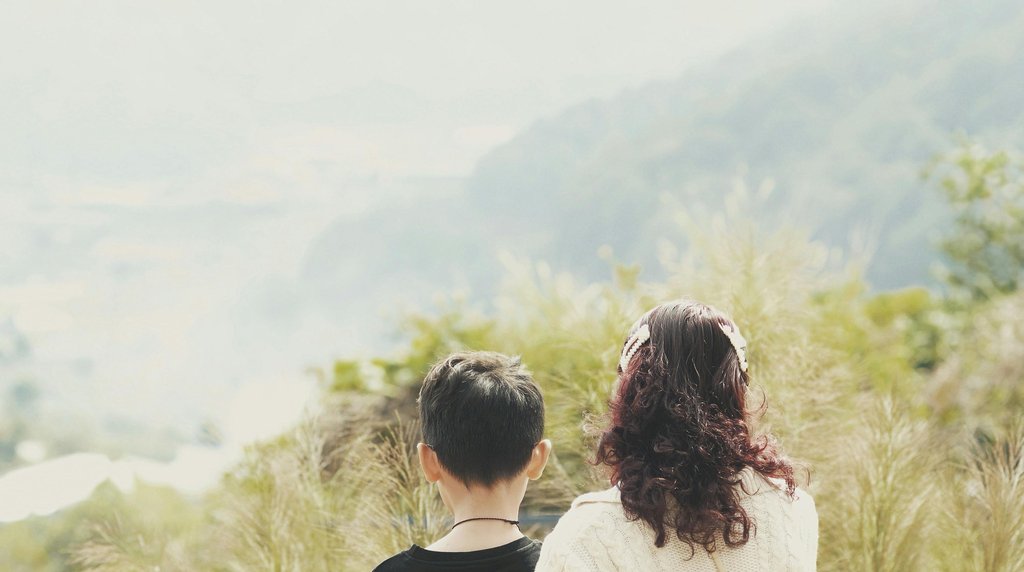 母と息子が山を眺めながら休む