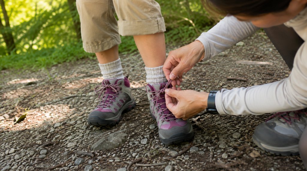 子どもの登山靴の靴ひもを結ぶ親の手元