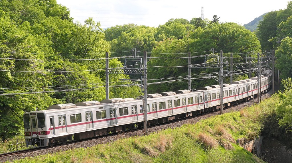 新緑の山あいを走る東武東上線の電車