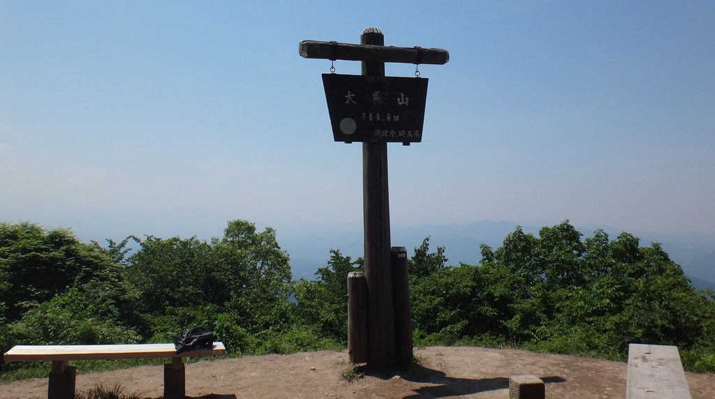 大霧山の山頂に立つ山名の標識とベンチ