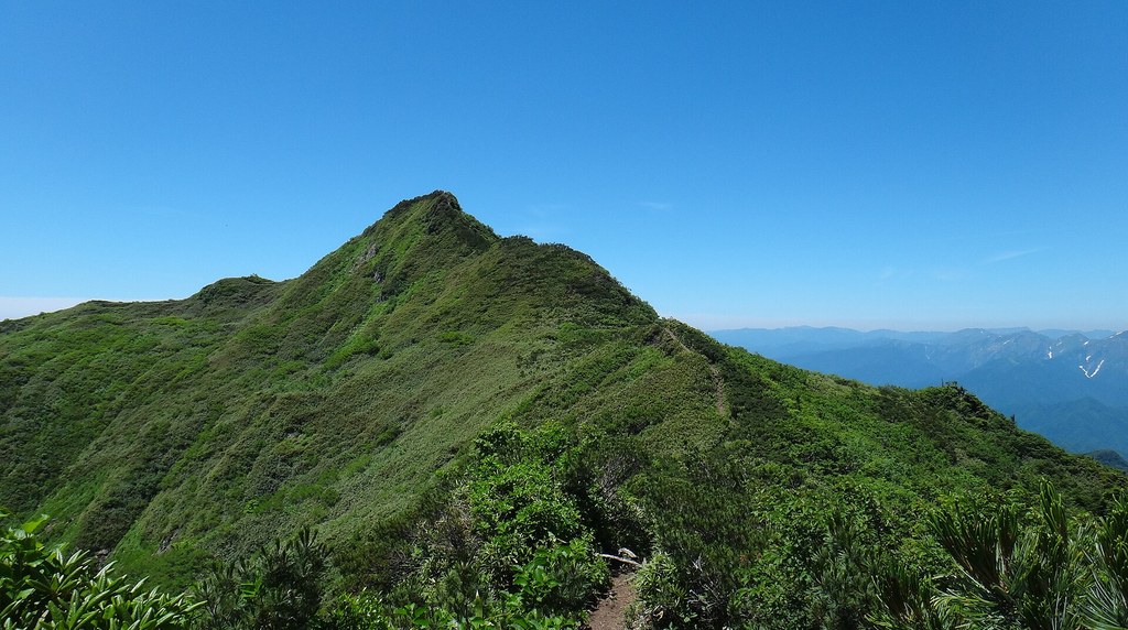 緑の尾根の先にとがって見える武尊山の剣ヶ峰